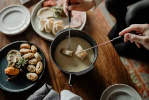 Appetizers on plates and people holding utensil dipping food
