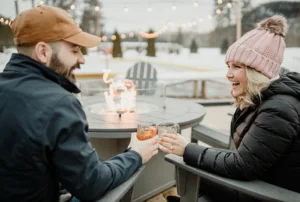 Couple sitting in chairs near outdoor fire pits