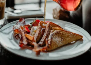 French toast with bacon and maple syrup being poured