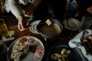 Appetizers on plates and person holding utensil dipping food