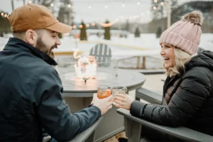 Couple sitting in chairs near outdoor fire pits